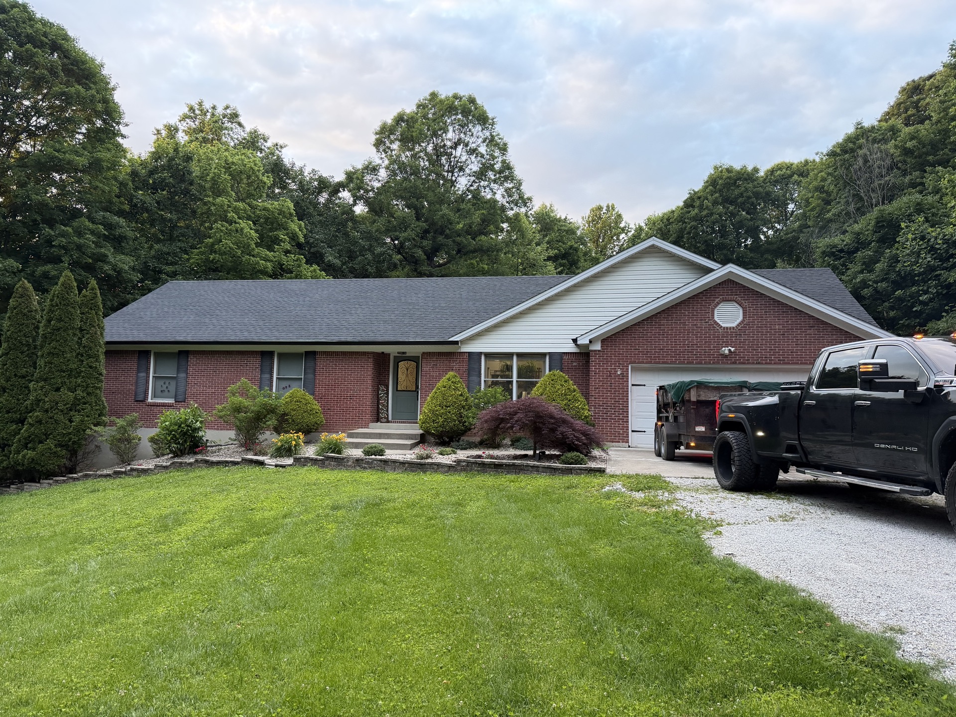 Finished brick and siding ranch home with a new dark shingle roof and attached garage.