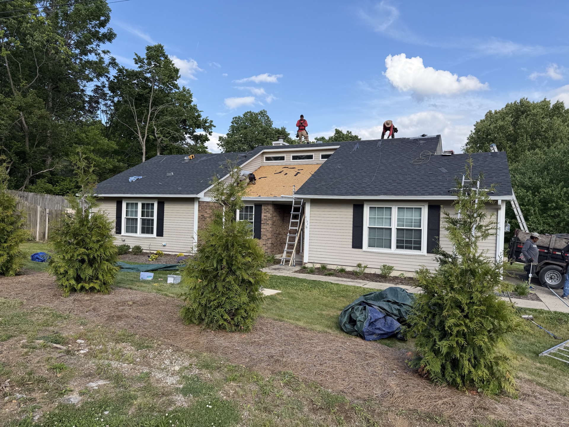 New Standard Roofing crew removing old shingles during a residential roof replacement.